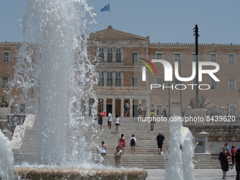 People walk past a fountain at Syntagma Square during a heatwave in Athens, Greece, on June 23, 2022 (