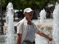 A man tries to cool off at a fountain at Syntagma Square during a heatwave in Athens, Greece, on June 23, 2022 (