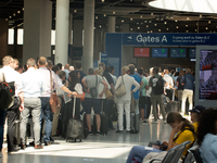 Travellers are seen waiting in a long line at a security check point at Duesseldorf airport in Duesseldorf, Germany on June 22, 2022 as staf...