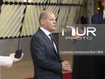 Olaf Scholz Federal Chancellor of Germany arrives at the EU summit, walking next to the European flags, flag of Europe and talks to the medi...