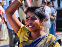 Tamil Hindu woman carries a pot containing milk with honey as she takes part in a religious procession escorting the chariot carrying the id...