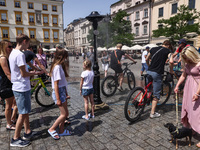 Tourists are having fun by a water sprinkler at the Main Square in Krakow, Poland on June 19, 2022. Hot air masses from over Africa covered...