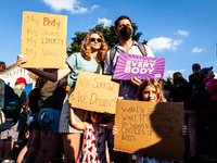 A family is among the thousands of people attending a protest for abortion access after the Supreme Court reversed the federal right to abor...