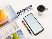 In this photo illustration a Matalan logo seen displayed on a smartphone screen on a desk next to a cafe, a pen, glasses and a magazine in A...