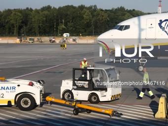 Ryanair airport vehicle
and ground staff are seen near the plane at the airport in Balice near Krakow, Poland on June 27, 2022. (