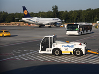 Airport vehicles and an airplane are seen at the airport in Balice near Krakow, Poland on June 27, 2022. (