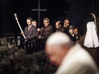 Rome, Italy – April 18, 2014: Faithful hold the cross during a station during the Via Crucis (Way of the Cross) torchlight procession celebr...