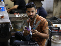 Palestinian workers sharp knives to be used to slaughter animals amidst preparations ahead of the Muslim festival of Eid al-Adha in Gaza Cit...