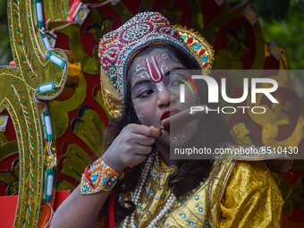 A girl, dressed as Hindu god Krishna, eats ice cream during the concluding ceremony of Jagannath Rath Yatra 2022, in Kolkata on July 09 2022...