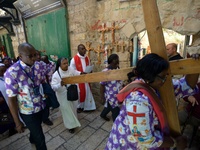 JERUSALEM, ISRAEL - APRIL 18: Orthodox Christian pilgrims carry a large cross along the Via Dolorosa on April 18, 2014 in Jerusalem's old ci...