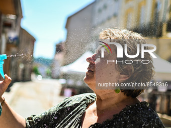 A woman sprays herself with water to cool down. France goes through an intense heatwave with really high temperatures.  (