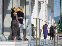 Tourists wearing hat seen outside Hotel Grande Bretagne at Syntagma square during high temperatures in Athens, Greece on July 17, 2022. (