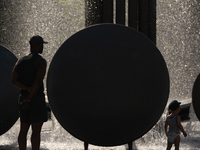 a father and kid is seen in a water fountain during  the heatwave continues in Cologne, Germany on July 19, 2022 as temperature reaches to 3...