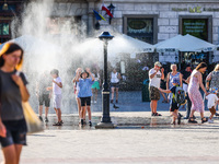 Tourists are cooling by a water sprinkler at the Main Square in Krakow, Poland on July 25, 2022. Hot air masses from over Africa covered mos...