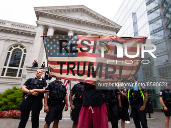 An anti-Trump protester stands in front of a police line separating protesters from a supporter during Trump’s speech at an America First co...
