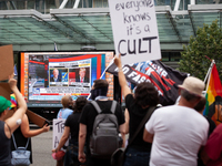 A truck playing Fox News' 2020 announcement that Biden won the presidential election passes people protesting Donald Trump's speech at an Am...