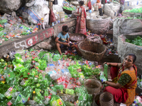 Workers sort through polyethylene terephthalate (PET) bottles in a recycling factory in Dhaka, Bangladesh, on July 27, 2022. Recycling plast...