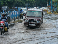 Commuters are seen crossing a flooded street after heavy afternoon rain in Kolkata , India , on 29 July 2022 . (