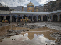 Loaders and a bulldozer clear mud at Imamzadeh Davood holy shrine after flash floods in the northwestern part of Tehran on July 29, 2022.  (