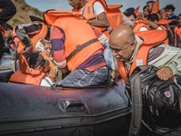 A Syrian man helps pull the dingy he arrived on further into the shores on the island of Lesbos, Greece, on September 26, 2015.  (