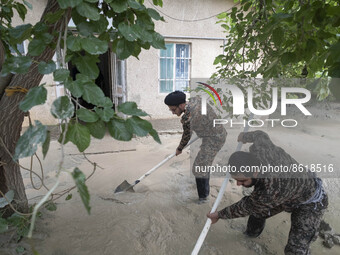 Two Iranian clerics clean mud at a building in the flooded village of Mazdaran in Firoozkooh county 124 km (77 miles) northeast of Tehran, f...