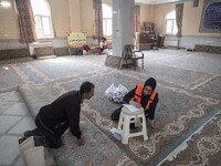 A villager speaks with an Iranian female health personnel at a mosque in the flooded village of Mazdaran in Firoozkooh county 124 km (77 mil...