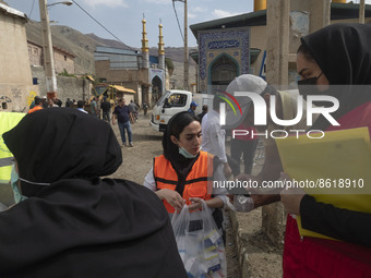 A volunteer speaks with an Iranian female doctor (C) as she holds a plastic bag loaded with medicines in the flooded village of Mazdaran in...