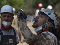A member of the Iranian Red Crescent Society (IRCC) drinks water as he prepares to search for a body of a flood victim, five days after a su...