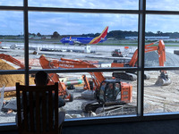 A traveler watches through a terminal window at construction on Baltimore/Washington International Thurgood Marshall Airport’s new Concourse...