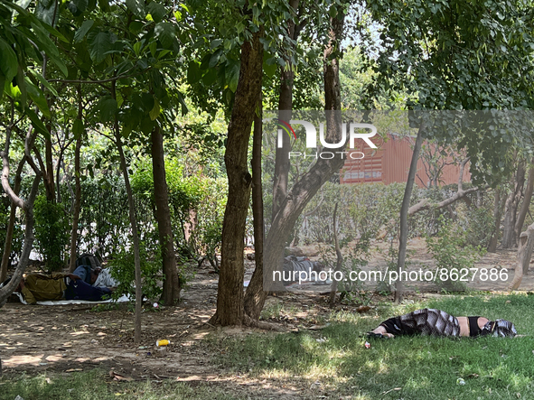 People sleep outside under the shade of tress to try and escape the heat during a heat wave in Greater Noida, India, on May 07, 2022. Temper...