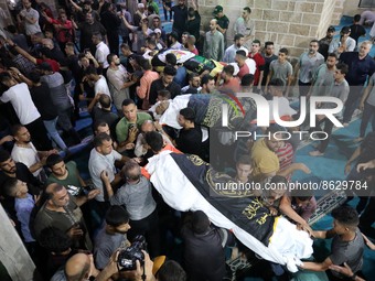 Palestinian mourners carry the bodies of the victims killed earlier in an Israeli air strike, during their funeral in Gaza City, on August 5...