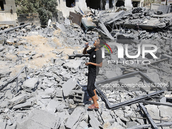 A Palestinian boy on the rubble of house destroyed by Israeli airstrikes, in Gaza City, on 06 August 2022. (
