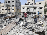Palestinians inspect buildings damaged after Israeli airstrikes in Gaza City, on 06 August 2022. (