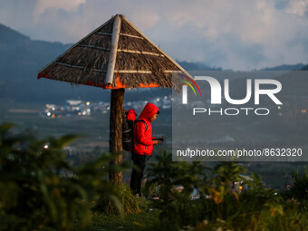 A tourist enjoys a view of the Dieng mountain area in Banjarnegara, Central Java province, Indonesia, on August 6, 2022. (