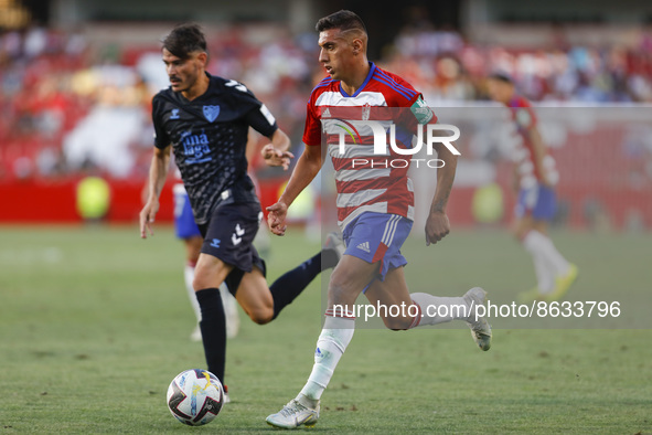 Myrto Uzuni, of Granada CF  and Jozabed Sanchez, of Malaga CF during the City of Granada Trophy match between Granada CF and Malaga CF at Nu...