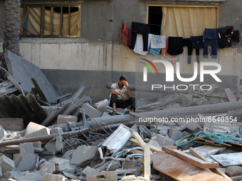 A Palestinian man sits amid the rubble inside his damaged home in Gaza city early on August 8, 2022, following a cease fire between Israel a...