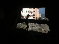 A Palestinian boy inspects damage outside a residential building in Gaza City August 8, 2022, following a cease fire proposed by Egypt betwe...