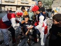 Palestinian children are entertained by clowns amidst the rubble of a building destroyed in the latest round of fighting between Israel and...