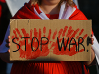A protester holding a placard with words 'Stop War!.Members of the local Belarusian and Ukrainian diaspora supported by local Cracovians du...