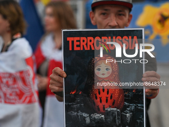 A protester holding a poster with words 'TerroRussia'.Members of the local Belarusian and Ukrainian diaspora supported by local Cracovians...