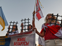 Protesters hold symbolic paper prison bars representing the Belarusian population in prisons and the lack of freedom in Belarus.Members of...