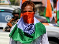 A Kashmiri man wraps his face in Indian National Flag Tri-Color during Tiranga Rally. BJP workers held Tri-Color (Tiranga) Rally in Baramull...