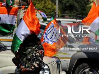 A CRPF Trooper stands alert near a BJP Flag and Indian National Flag. BJP workers held Tri-Color (Tiranga) Rally in Baramulla Jammu and Kash...