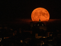 A sturgeon Super Moon rising behind San Bernardino church dome in L'Aquila (Abruzzo, Italy), on august 12, 2022. August full moon is the las...