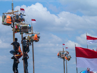 Participants struggle to climb a greasy pole to claim prizes in the 