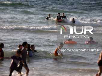Palestinians enjoy in the Mediterranean sea in Gaza City on August 17, 2022.
 (