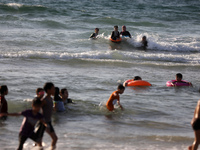 Palestinians enjoy in the Mediterranean sea in Gaza City on August 17, 2022.
 (
