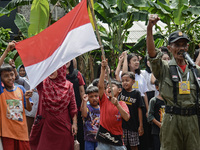 Residents gesturing as they attend during a ceremony to mark the 77th Indonesian Independence Day in Bogor, West Java, Indonesia, on August...