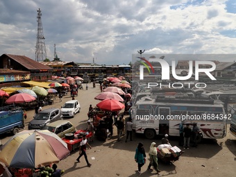 Commuters walk as passenger vehicles are parked at General Bus Stand Sopore District Baramulla Jammu and Kashmir India on 18 August 2022 (
