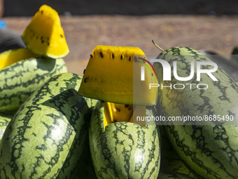 A street vendor sells yellow watermelon in a street at Dhaka, Bangladesh on August 18, 2022. (